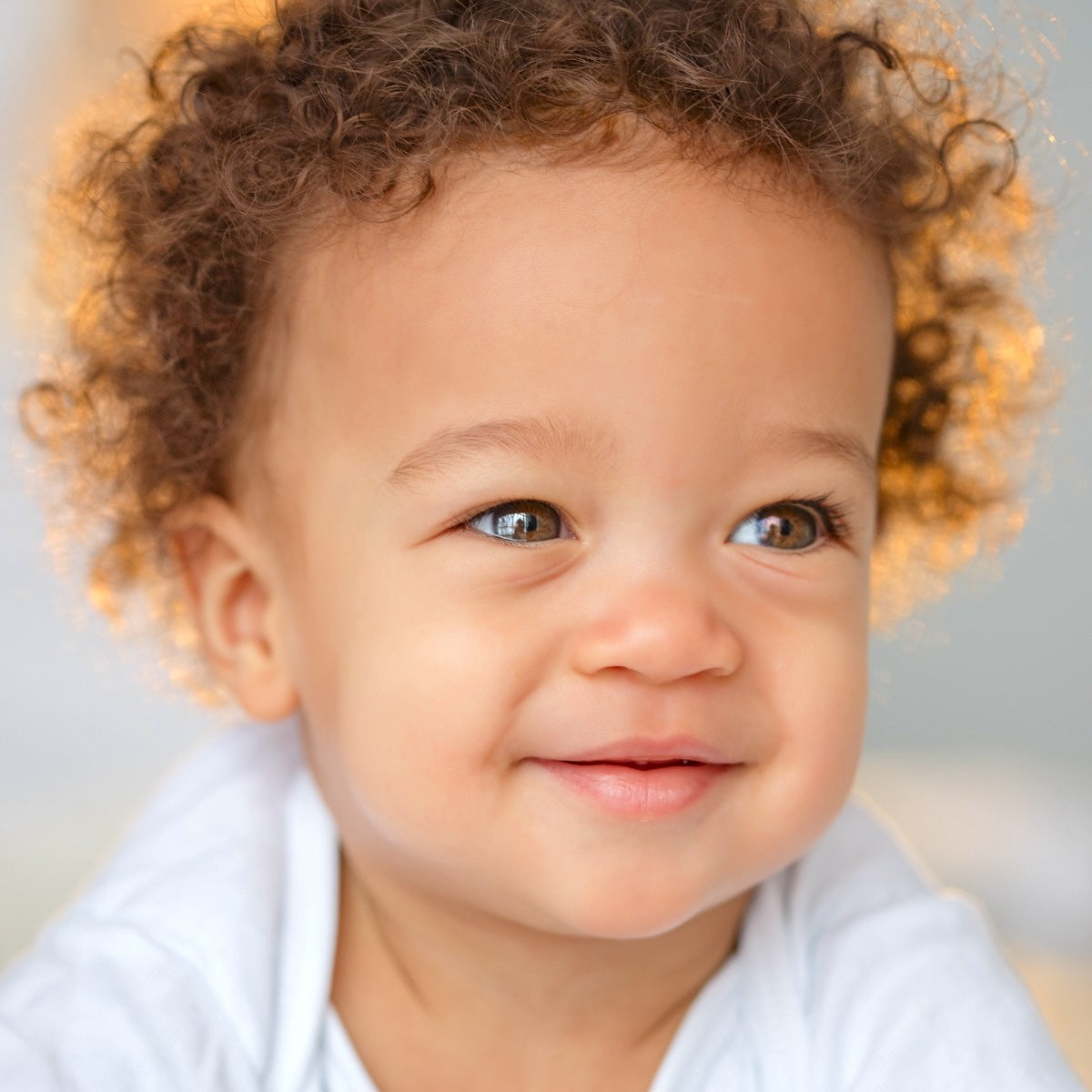 Sweet little baby with dark super curly hair