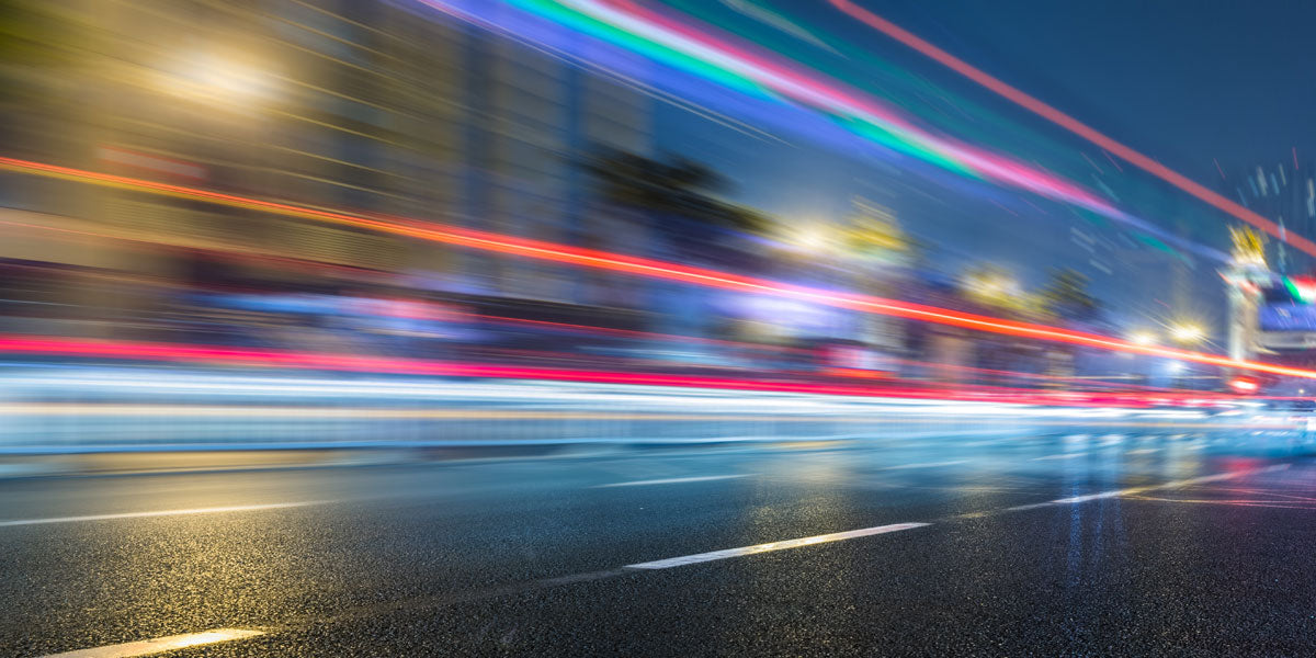 Dark roadway at night with blurred vehicle lights