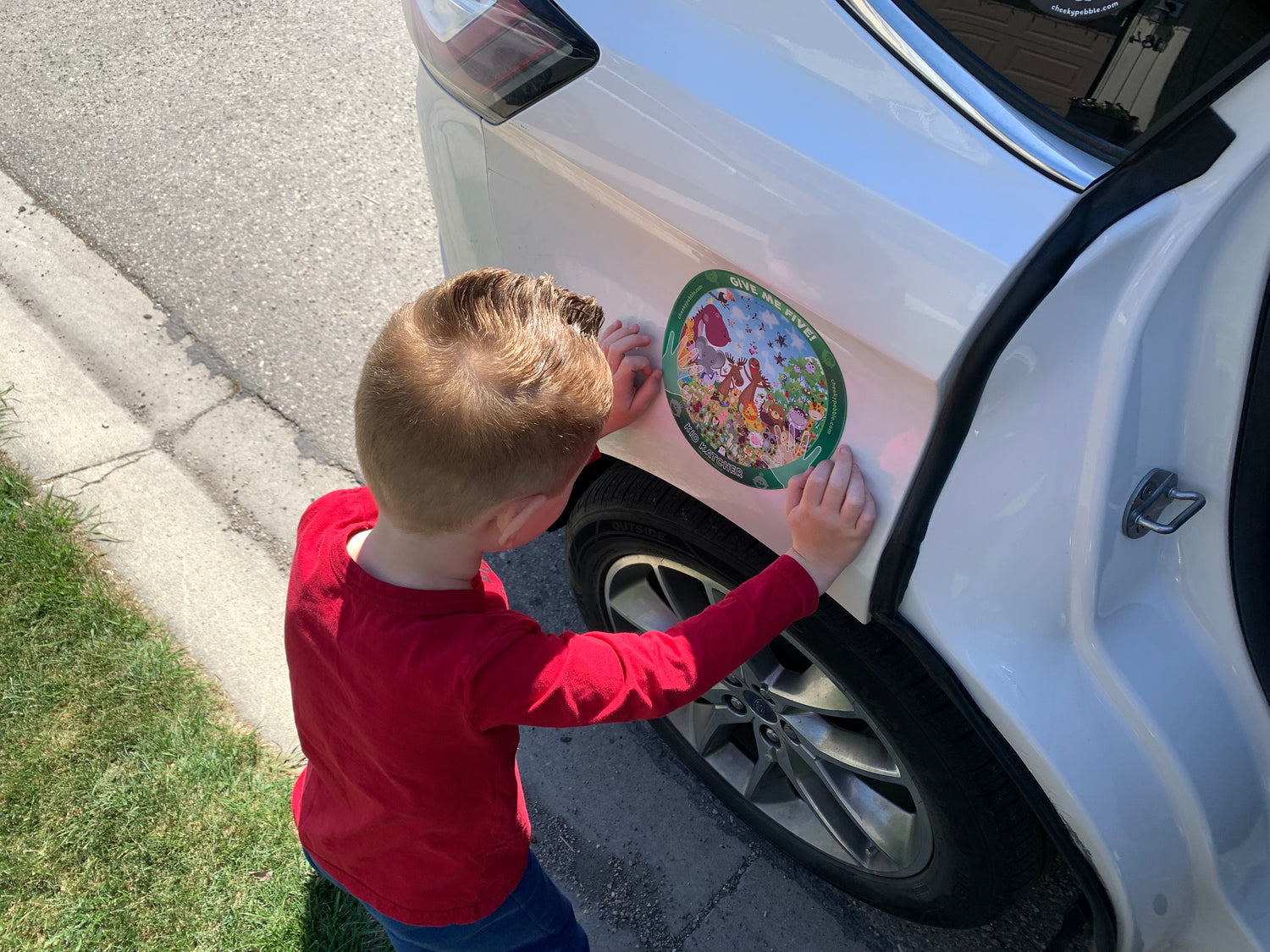 Image of a child searching the animal Kid Katcher toddler magnet that is placed on a vehicle in the recommended Safe Zone.