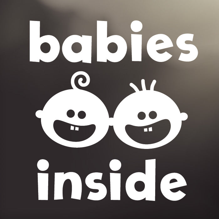 ‘Babies Inside’ large, white vinyl, back window decal by Cheeky Pebble with iconic Cheeky and Curly Cue faces. Designed for placement on dark, tinted vehicle windows. 