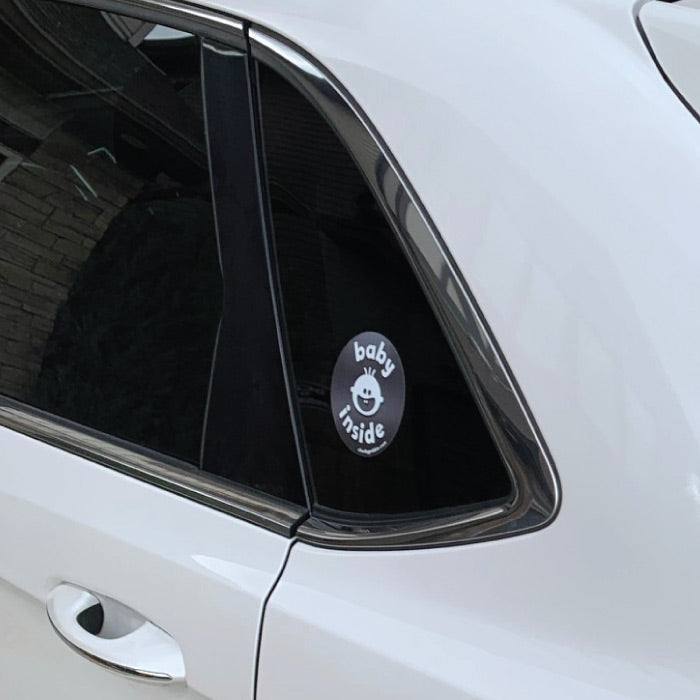 Close up of 'Baby Inside' side sticker on a white SUV.