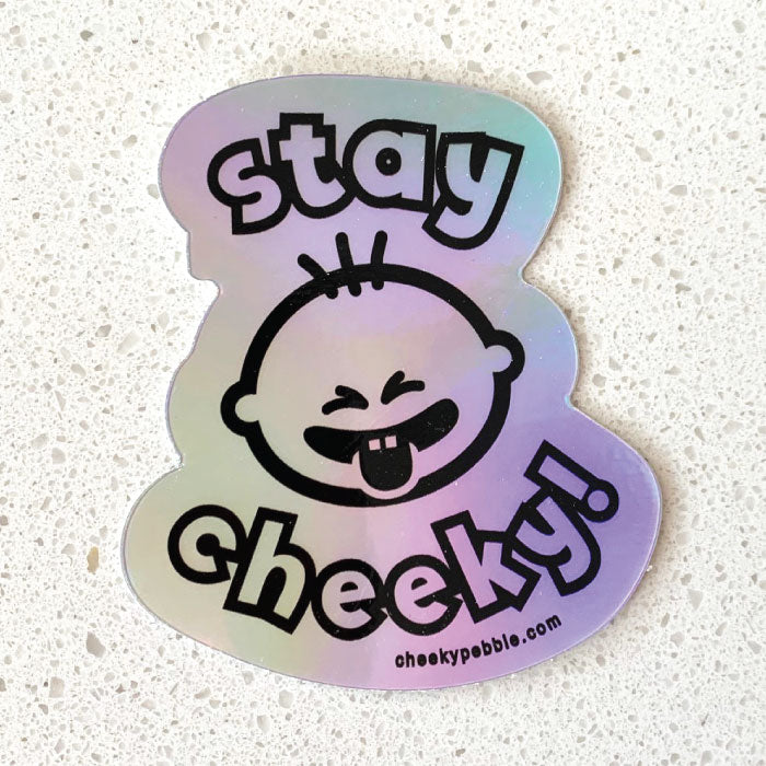 Stay Cheeky Sticker by Cheeky Pebble in holographic material on white countertop.