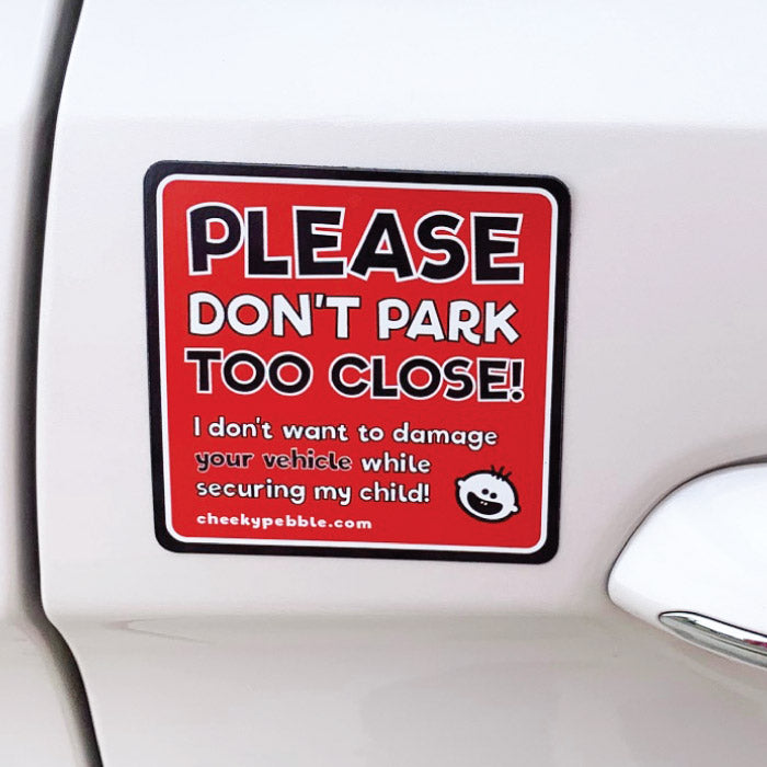 Please Don’t Park Too Close Child Specific Magnet by Cheeky Pebble. Close up on white vehicle. Reads: Please Don’t Park Too Close! I don’t want to damage your vehicle while securing my child.