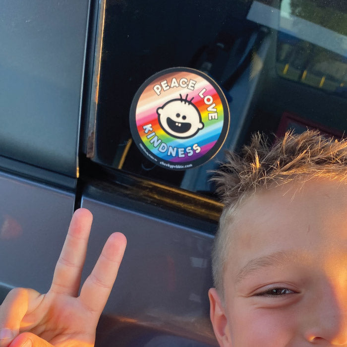 Peace Love Kindness 4x4 inch sticker by Cheeky Pebble on a vehicle window with young boy giving the Peace sign with his fingers.