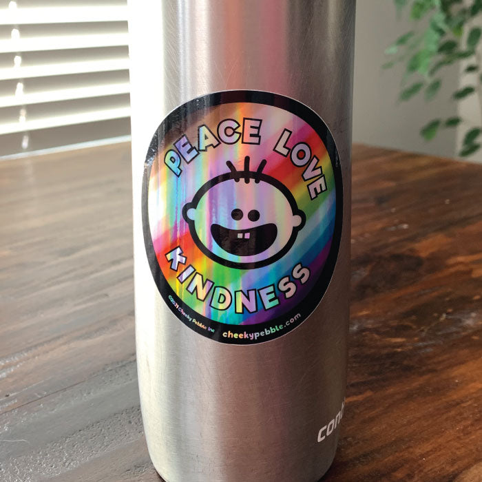 Peace Love Kindness 3x3 inch holographic sticker by Cheeky Pebble on a stainless steel travel mug.